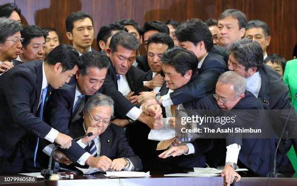 Opposition lawmakers gather at the Upper House Justice Committee chairman Shinichi Yokoyama as the Liberal Democratic Party and its junior coalition...