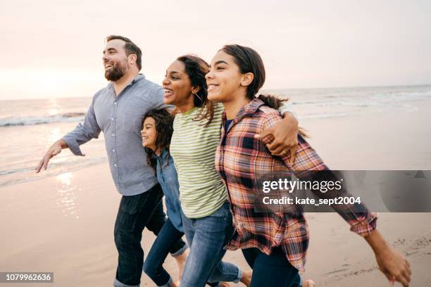 tramonto in spiaggia con la famiglia - couple running on beach foto e immagini stock