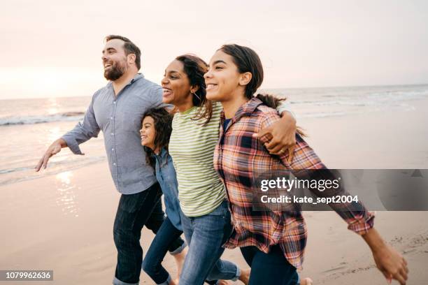 sunset at the beach with family - two parents two kids stock pictures, royalty-free photos & images