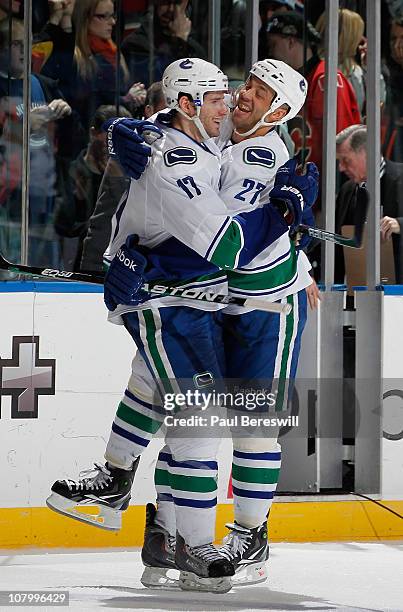 Ryan Kesler of the Vancouver Canucks is hugged by teammate Manny Malhotra as they celebrate the winning goal by Kesler in the shootout of an NHL...