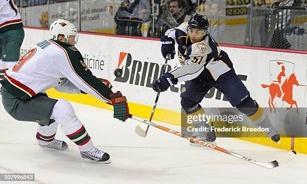 Francis Bouillon of the Nashville Predators passes the puck past Mikko Koivu of the Minnesota Wild on January 11, 2011 at the Bridgestone Arena in...