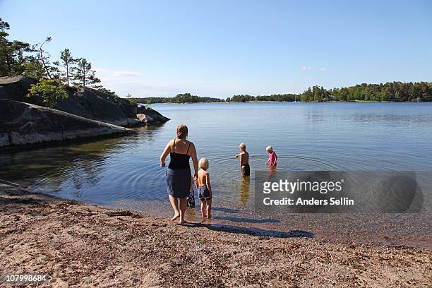 family at a small beach in archipelago - stockholm beach stock pictures, royalty-free photos & images