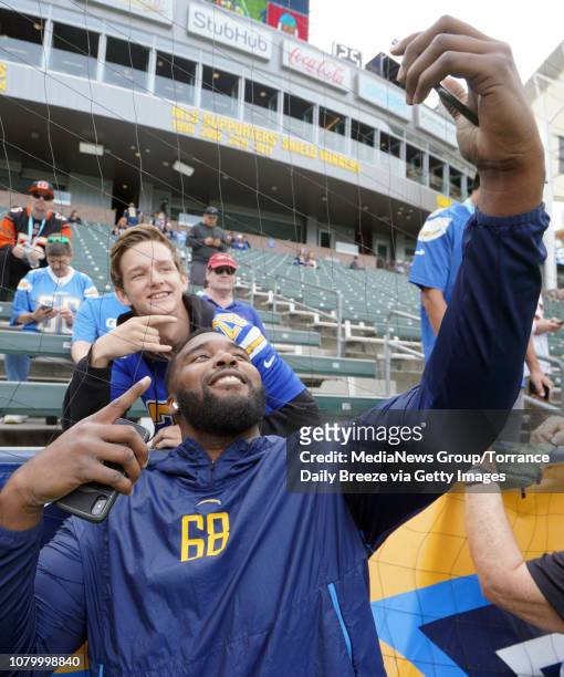 Los Angeles Chargers offensive tackle Trent Scott takes a selfie with a fan before the game against Cincinnati at StubHub Center in Carson on Sunday,...