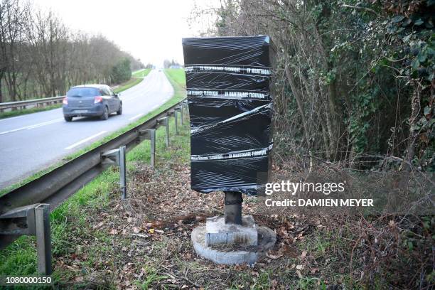 This picture taken on January 8 in Saint-Jean-sur-Vilaine, western France, shows a burnt fixed speed camera covered with plastic and tape reading...