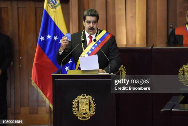 Nicolas Maduro, Venezuela's president, holds a copy of the constitution while speaking after being sworn in during the presidential inauguration at...