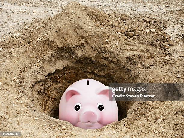 piggy bank stuck in dirt hole - trou sol photos et images de collection