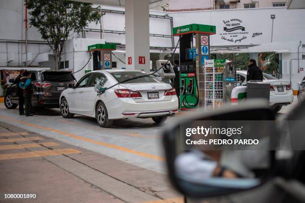 Pemex petrol station attendant fills up the tank of a car in Mexico City on January 10, 2019. - President Andres Manuel Lopez Obrador urged Mexicans...