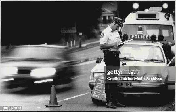 New Year Eve's Random Breath Testing -- Constable Trent Le-Merton fills out his stat sheet on Victoria Rd, Ryde. December 31, 1985. .