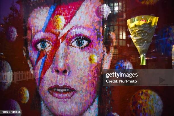 Fans pay tributes with flowers, candles and photos of David Bowie in Brixton, London on January 10, 2019. The iconic British musician died two days...