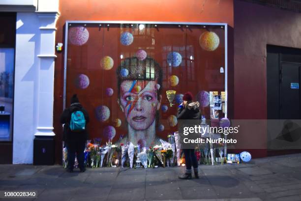 Fans pay tributes with flowers, candles and photos of David Bowie in Brixton, London on January 10, 2019. The iconic British musician died two days...