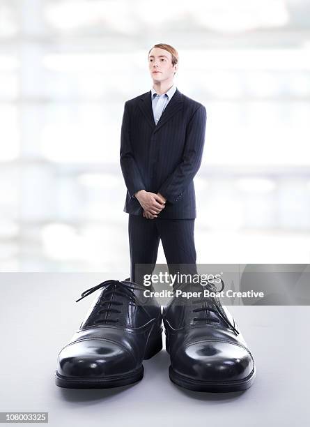 business man wearing extremely large black shoes - black shoe 個照片及圖片檔