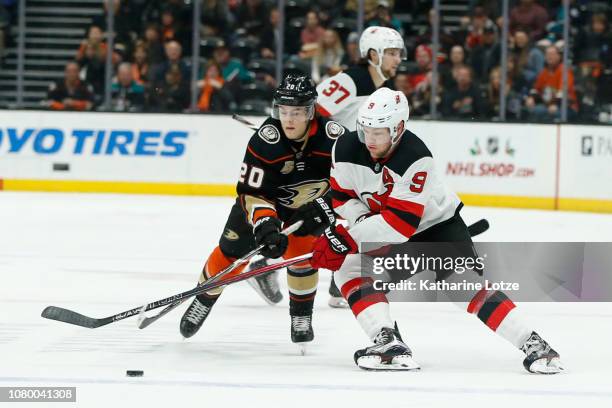 Pontus Aberg of the Anaheim Ducks and Taylor Hall of the New Jersey Devils fight for control of the puck at Honda Center on December 09, 2018 in...