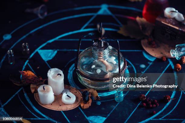 alchemist workplace with lab burner, candles, and chalk pentagram. magical still life on a dark background with copy space. - pentagram stock pictures, royalty-free photos & images