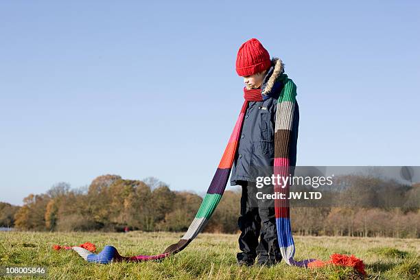 boy in park wearing long knitted scarf - think big stock pictures, royalty-free photos & images