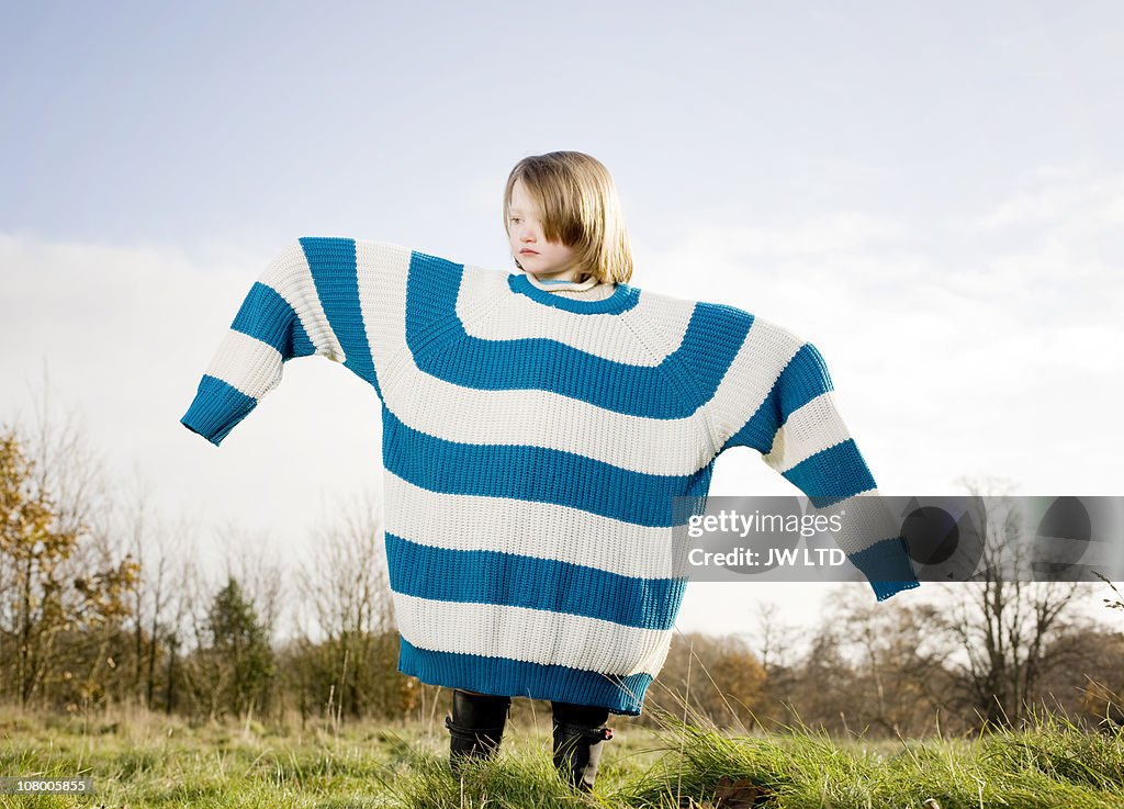 Girl wearing oversized jumper, arms out