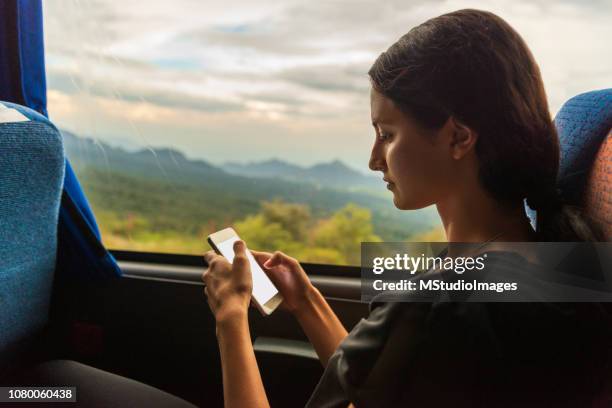 Young woman using mobile phone in the bus.