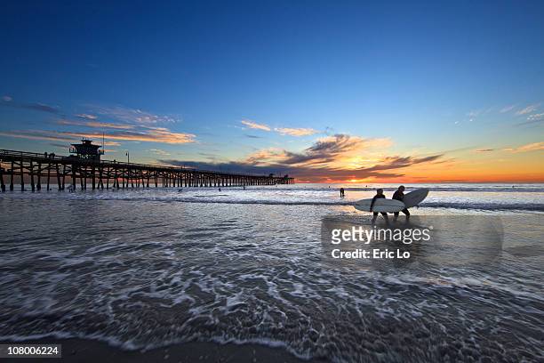girl surfers at twilight - californie surf stockfoto's en -beelden