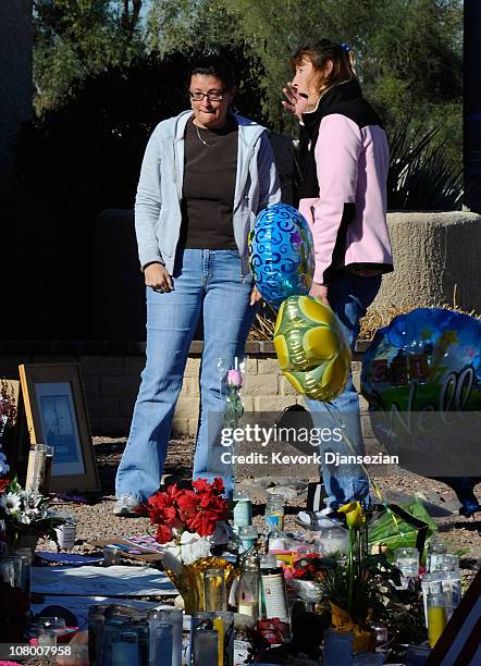 Chris Haffa and Barb Tuttle are overcome with emotion at a makeshift memorial outside the office of Rep. Gabrielle Giffords on January 12, 2011 in...