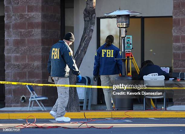 Agents collect evidence from the shooting scene in the La Toscana Village parking lot on January 12, 2011 in Tucson, Arizona. U.S. Rep. Gabrielle...