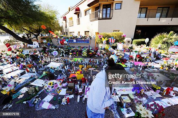 Barb Tuttle is overcome with emotion at a makeshift memorial outside the office of Rep. Gabrielle Giffords on January 12, 2011 in Tucson, Arizona....
