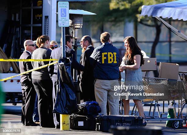 Agents process the shooting scene on in the La Toscana Village parking lot on January 12, 2011 in Tucson, Arizona. U.S. Rep. Gabrielle Giffords was...