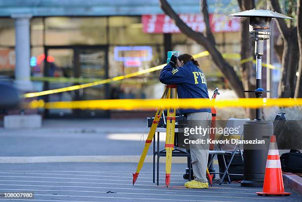 Agents collect evidence from the shooting scene in the La Toscana Village parking lot on January 12, 2011 in Tucson, Arizona. U.S. Rep. Gabrielle...