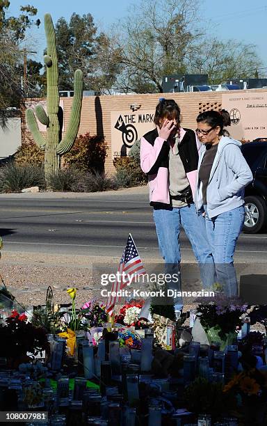 Chris Haffa and Barb Tuttle are overcome with emotion at a makeshift memorial outside the office of Rep. Gabrielle Giffords on January 12, 2011 in...