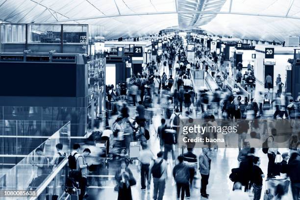 blurred people walking in airport - crowded airport stock pictures, royalty-free photos & images