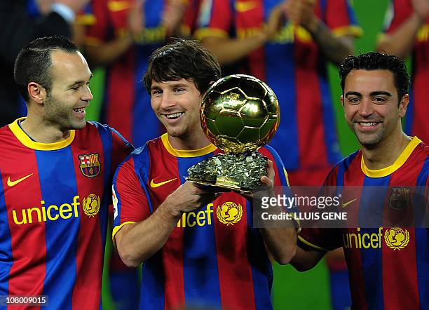 Barcelona's Argentinian forward Lionel Messi , flanked with Barcelona's midfielder Xavi Hernandez and Barcelona's midfielder Andres Iniesta , poses...