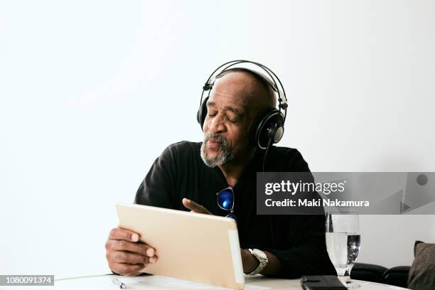 a skilled black musician is making a song using a tablet - gospel music stockfoto's en -beelden