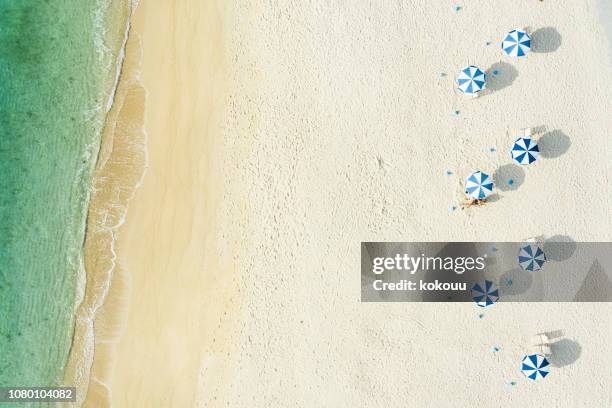 gens qui se détendre sur une belle mer et plage - umbrellas from above photos et images de collection