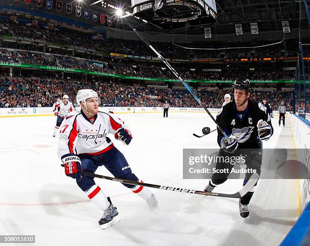 Vincent Lecavalier of the Tampa Bay Lightning blocks the puck as Karl Alzner of the Washington Capitals tries to clear it out of the zone during the...