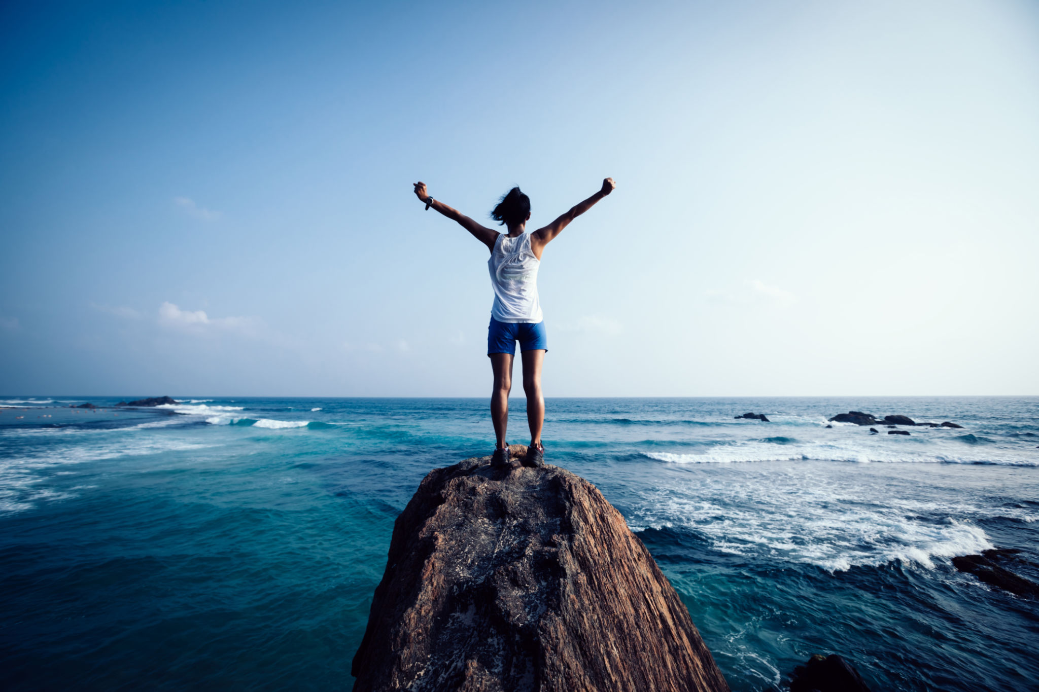 Freedom young woman outstretched arms on seaside rock cliff edge Freedom young woman outstretched arms on seaside rock cliff edge