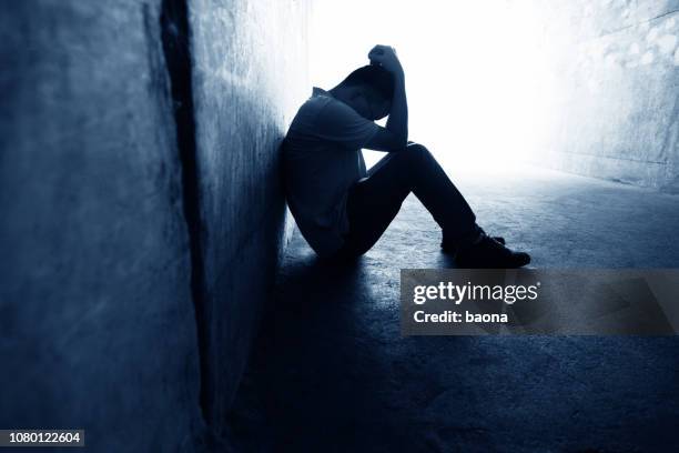 desperate man sitting in the tunnel - upset man stock pictures, royalty-free photos & images