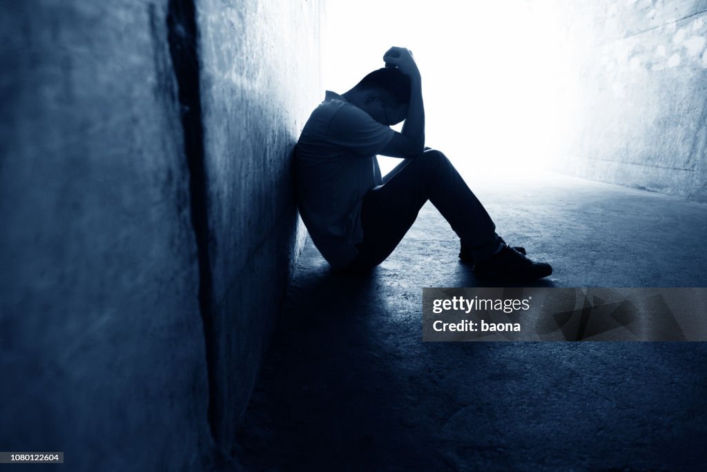 Desperate man sitting in the tunnel