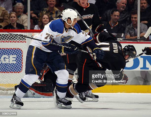 Ryan Reaves of the St. Louis Blues knocks down Saku Koivu of the Anaheim Ducks at the Honda Center on January 12, 2011 in Anaheim, California.
