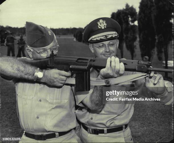 Army Major J.J. Sinnott, sights up Australia's new F.N. Rifle. Major R.M. Ripley of Headquarters, U.S. Army Pacific, Fort Shafter, Hawaii looks...