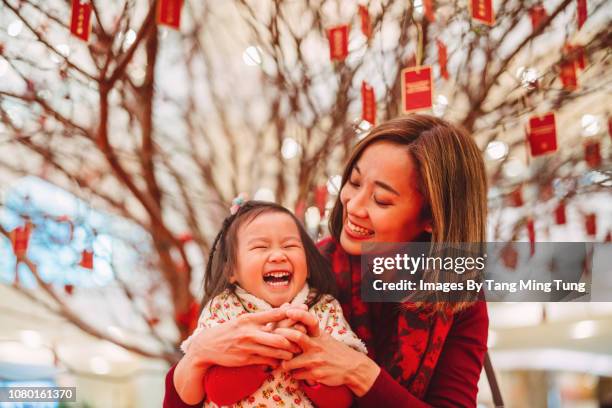 pretty young mom making kung hei fat choy hand gesture with her lovely daughter joyfully in chinese new year - 中國新年 個照片及圖片檔