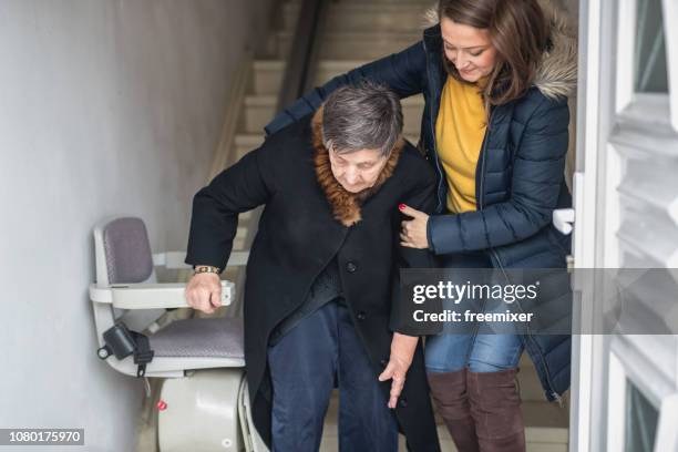 old woman moving down the stairs - going down staircase stock pictures, royalty-free photos & images