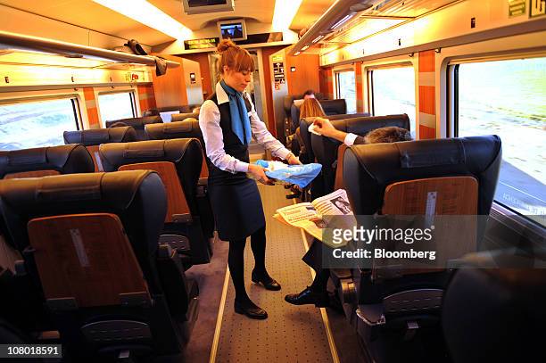 An employee attends a business class passenger travelling on board an Alta Velocidad Espanola high-speed on the Madrid to Valencia rail link in...