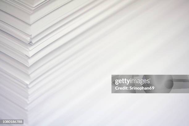 stack white paper isolated on white background with clipping path. stack of blank paper. paper stack in bin of offset printing press. - selective focus with noise and blur - stampatore foto e immagini stock