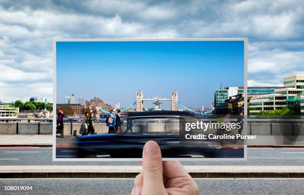 hand holding postcard of tower bridge, london - postkarte stock-fotos und bilder