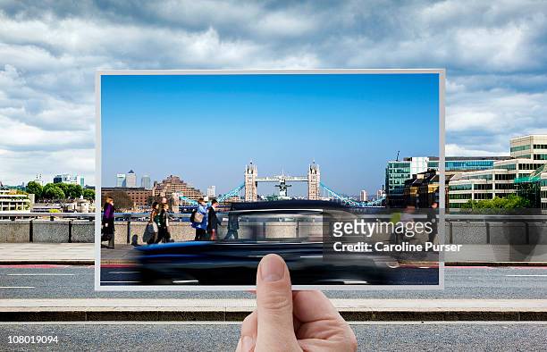 hand holding postcard of tower bridge, london - cartolina postale foto e immagini stock