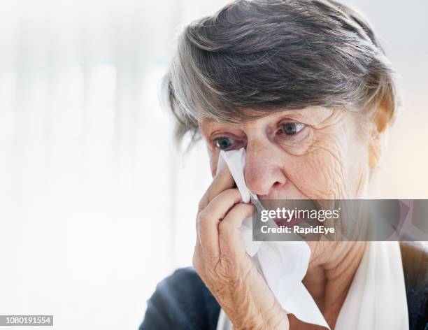 unglücklich sucht senior frau betupfen augen - eyes crying stock-fotos und bilder