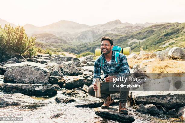 happy hiker by a mountain stream - asian drinking water stock pictures, royalty-free photos & images