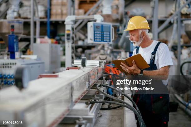 obrero mayor - maquinaria de fábrica fotografías e imágenes de stock