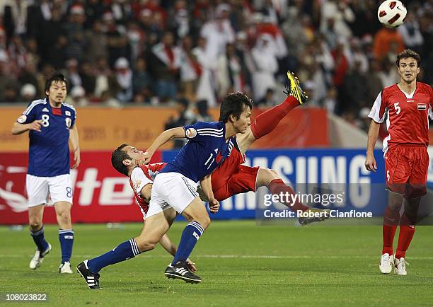 Abdulrazak Al Husein clears the ball away from Ryoichi Maeda of Japan during the AFC Asian Cup Group B match between Syria and Japan at Qatar Sports...