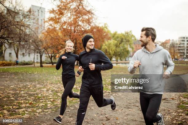 small group of people running in park - woman tracksuit stock pictures, royalty-free photos & images