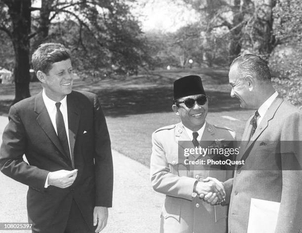 President of Indonesia Sukarno shakes hands with US Vice President Lyndon Johnson as President John F. Kennedy smiles, Washington DC, April 25, 1961.