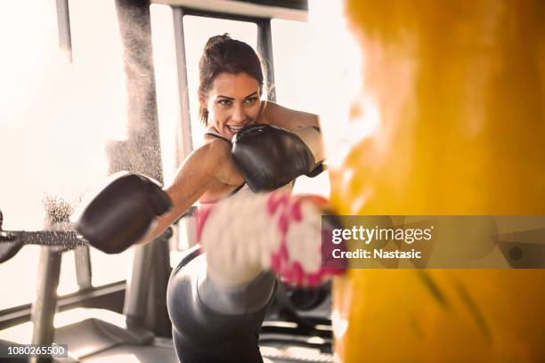 young woman training with punching bag - high kick stock pictures, royalty-free photos & images